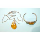 A silver-mounted amber pendant on leaf-link silver chain and a silver bangle set amber, (2).