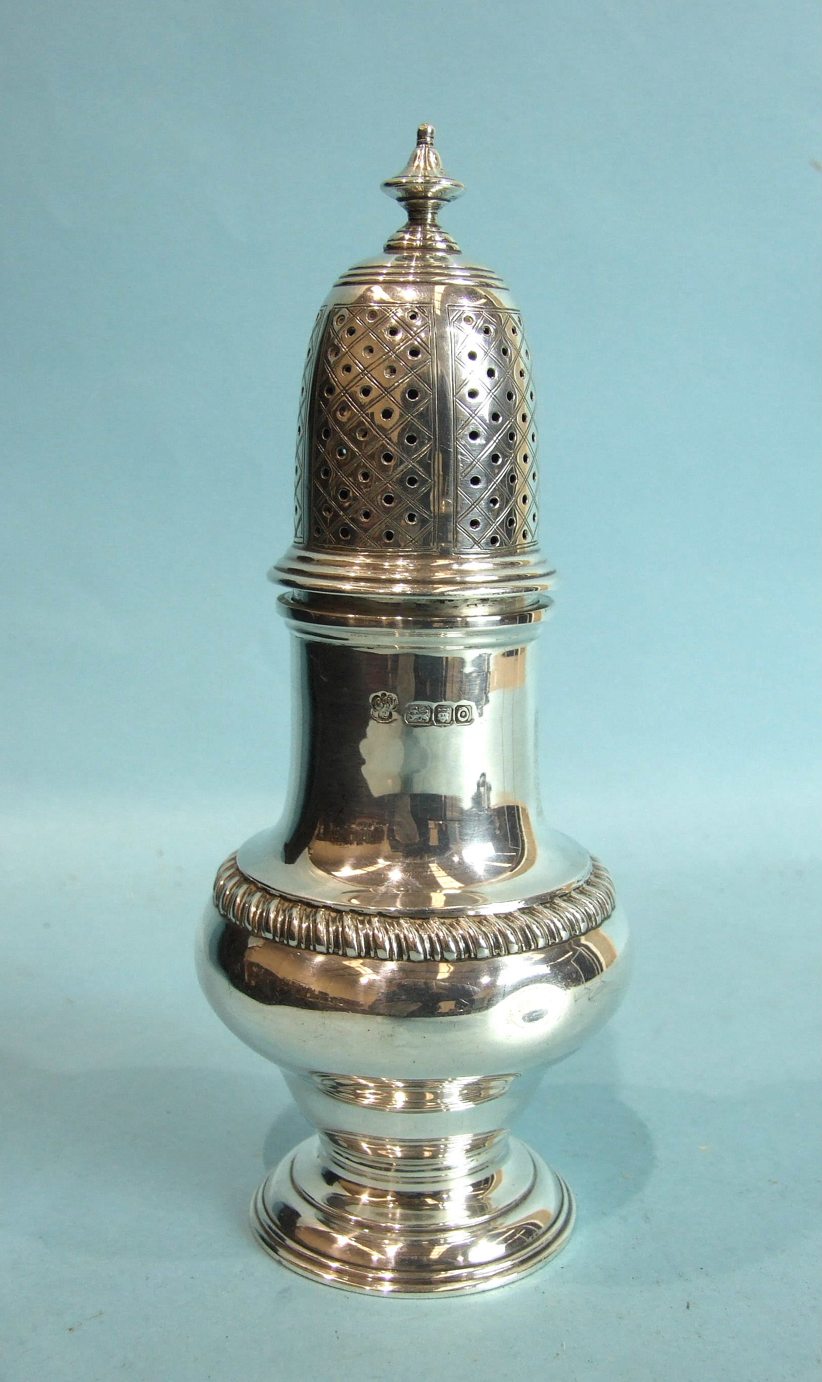 A heavy baluster-shaped sugar caster with finialled pierced cover and gadrooned girdle, on