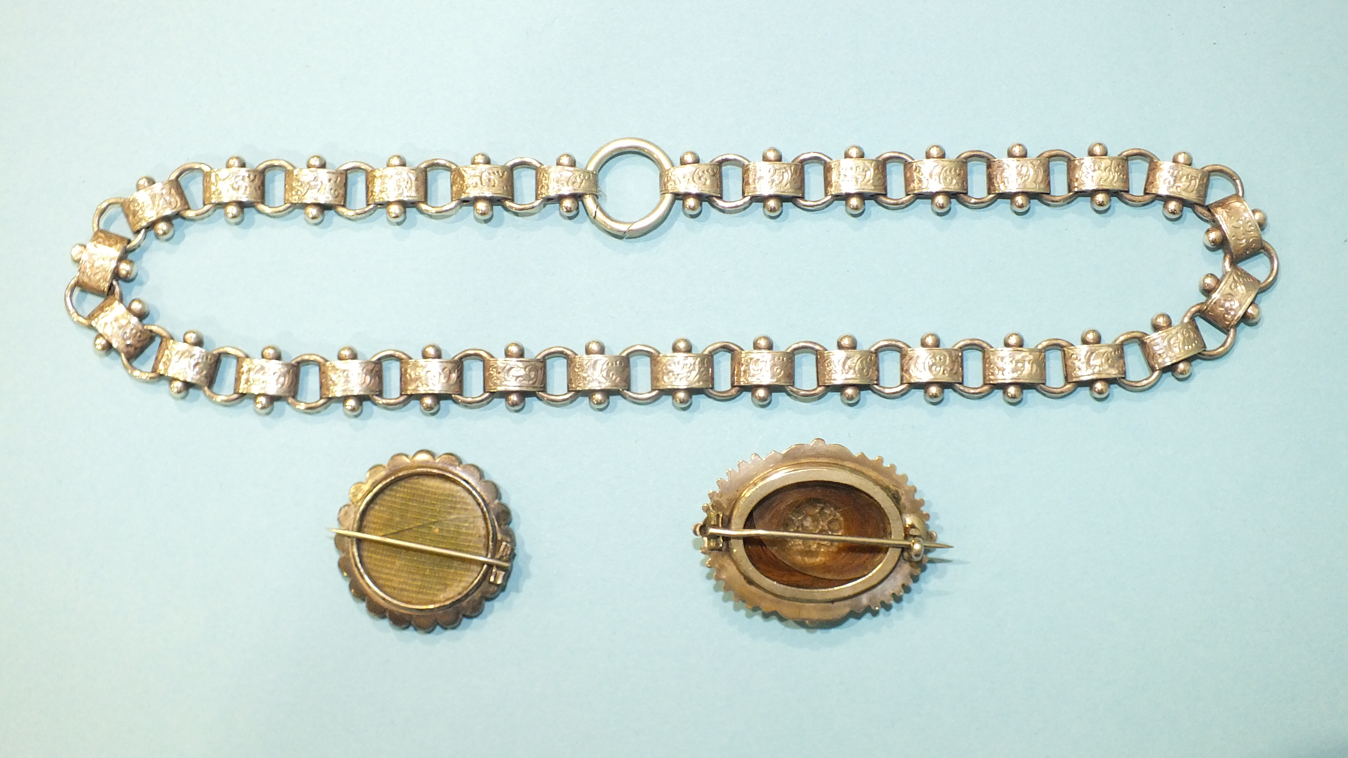 A Victorian silver necklace of engraved links and two silver locket-back brooches, (1 a/f), (3). - Image 2 of 2