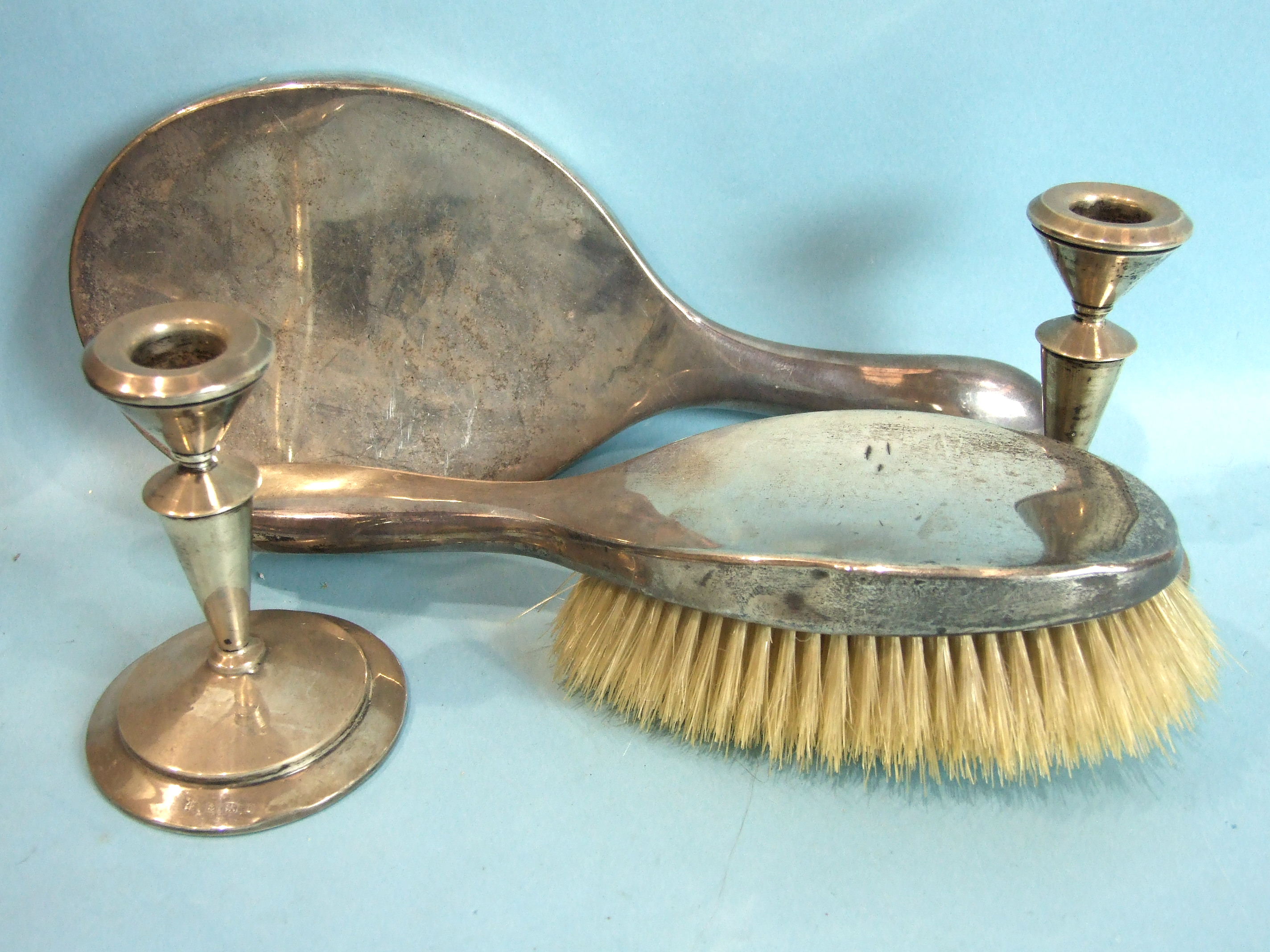 A pair of plain dressing table candlesticks, Birmingham 1910, 11cm high, a silver-backed oval mirror