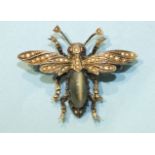 A silver bee brooch claw-set a chrysoberyl cat's eye, with pearl-set wings and red paste eyes,