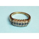 A sapphire and diamond ring claw-set a row of seven small round-cut sapphires, between two rows of