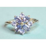 A tanzanite and diamond flower head cluster ring with 9ct white gold mount, size P, 2.6g.