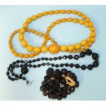 A string of yellow amber-type Bakelite graduated beads, 37g, a string of graduated faceted jet beads
