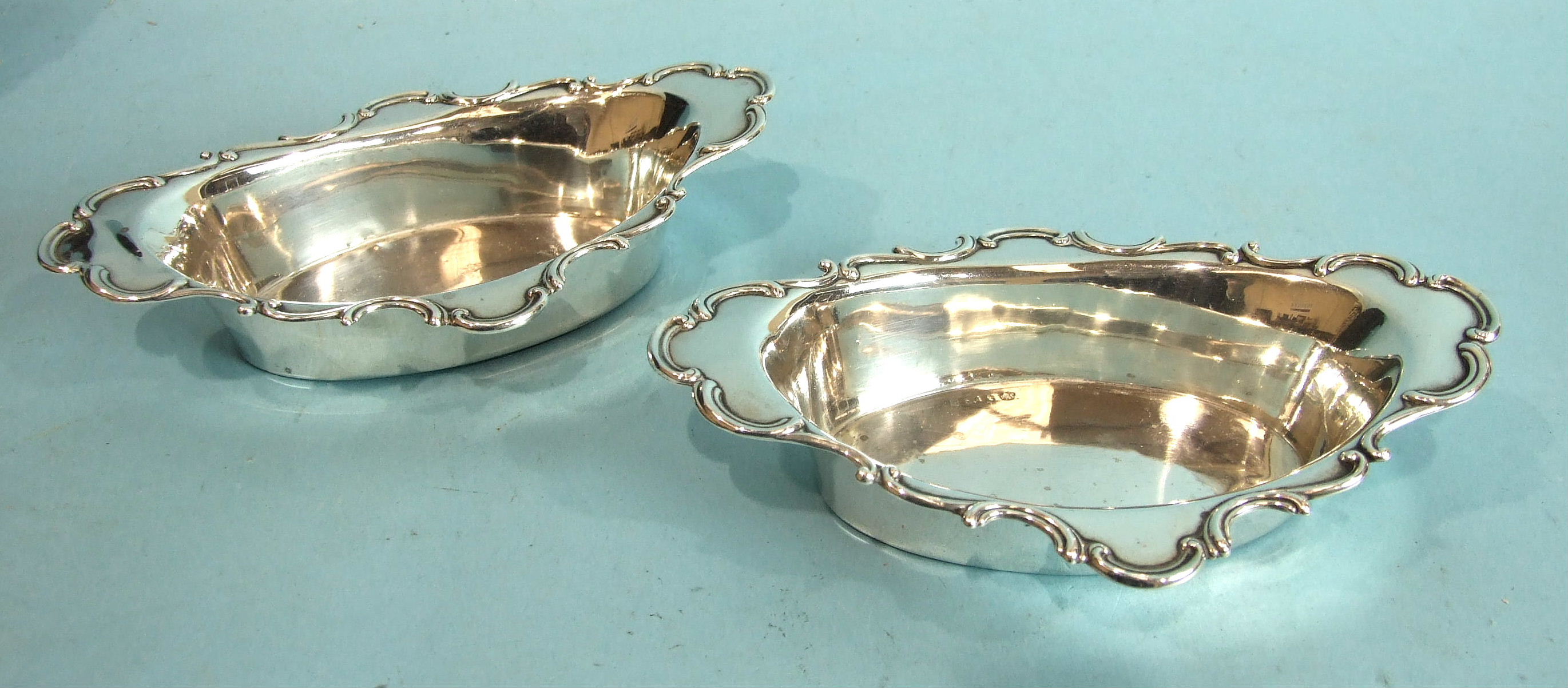 A pair of oval sweetmeat dishes with shaped scroll-edged rims, 17 x 10.5cm, Birmingham 1904,