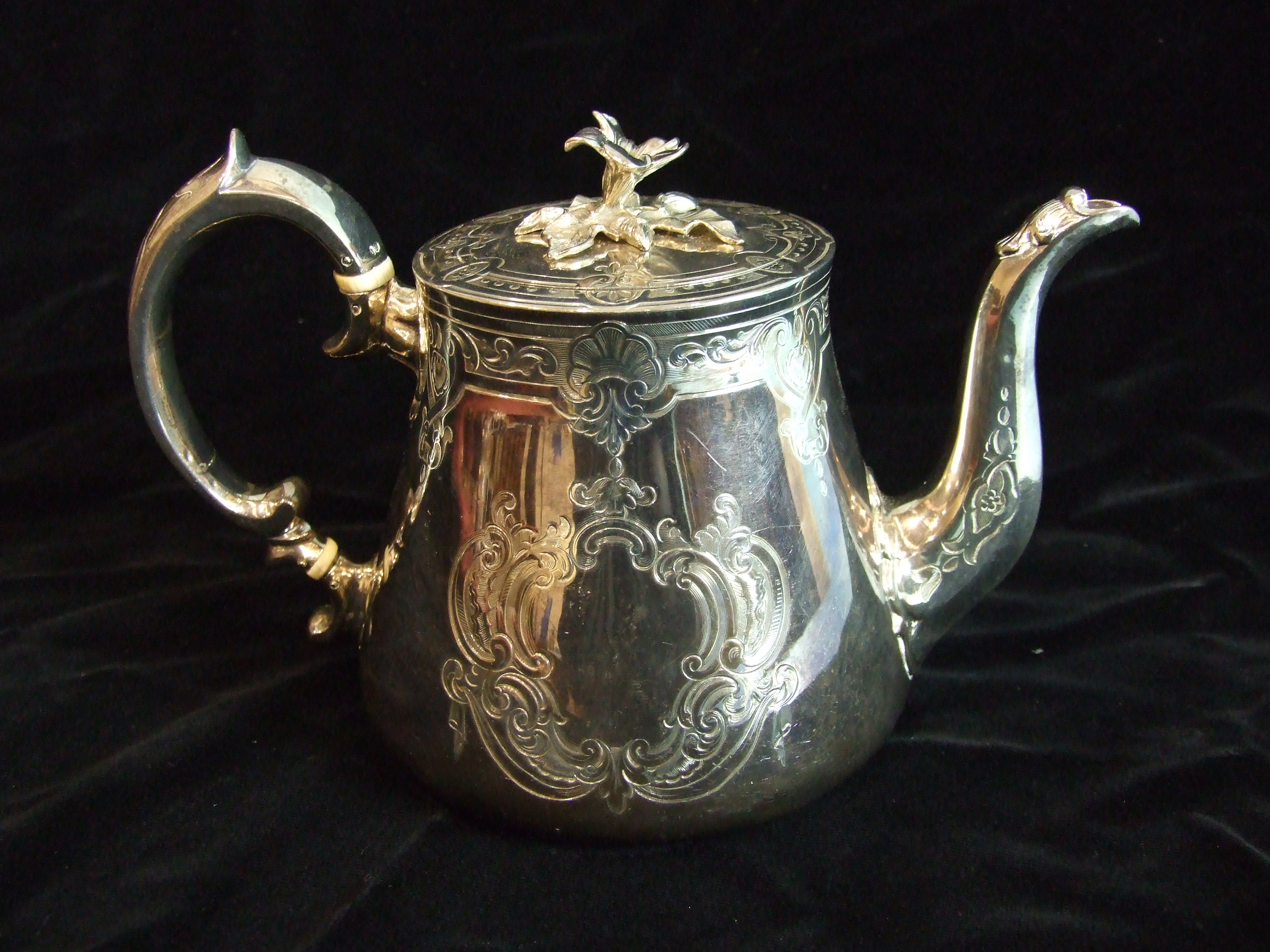 A Victorian teapot of tapered form and good gauge, with flower finial lid, the body engraved with