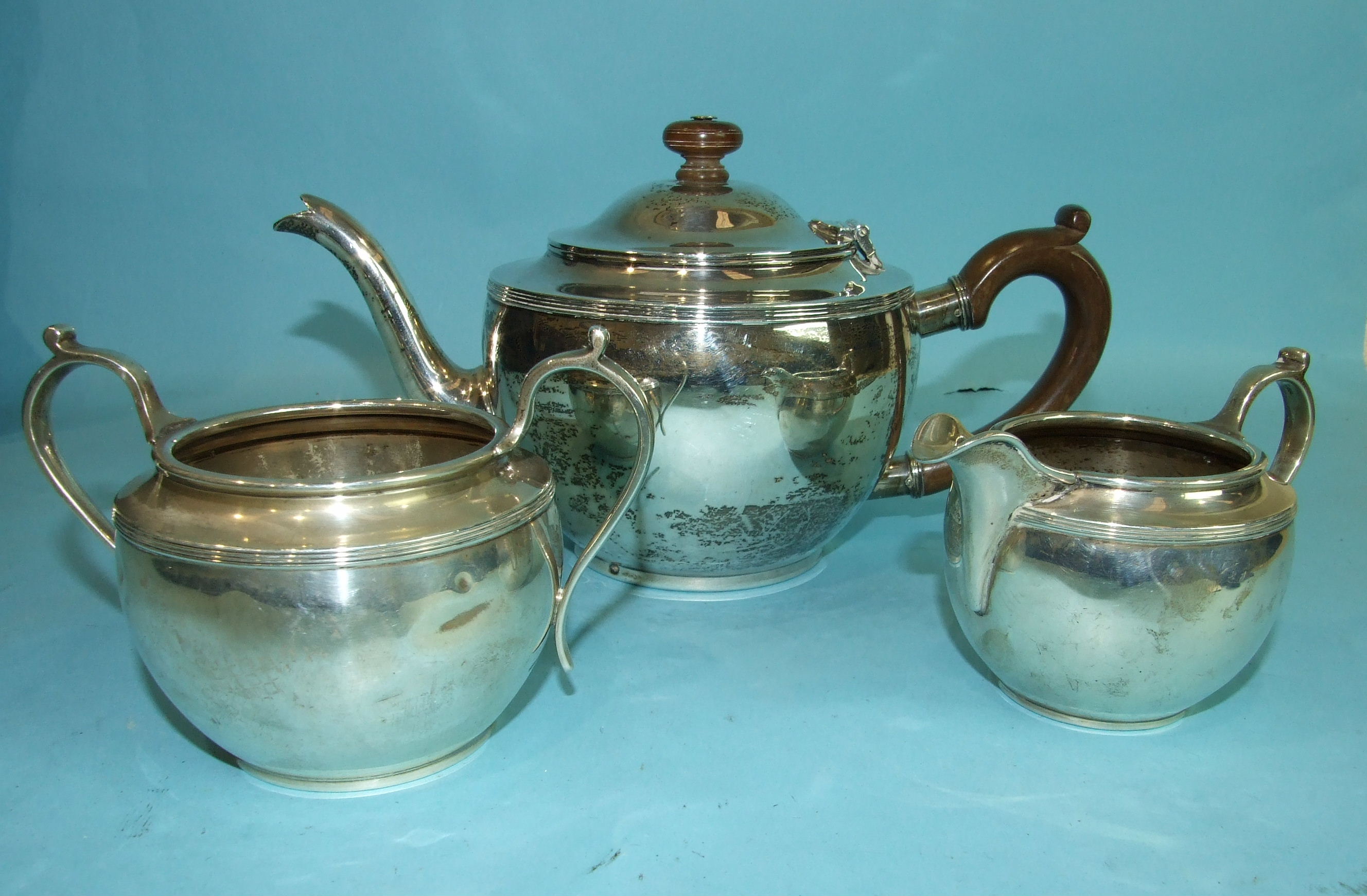 A plain circular three-piece tea service, London 1929, ___21½oz, inclusive, (dents overall).