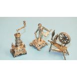 A silver miniature model of a coffee grinder, 65mm high, a silver miniature spinning wheel, 52mm