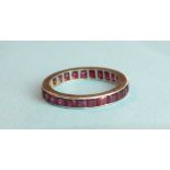A ruby full-eternity ring set with calibre-cut rubies, in unmarked white metal mount, size M, 2.6g.