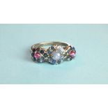 A sapphire and ruby ring set a cluster of a star sapphire cabochon within a surround of round-cut