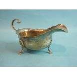 A 20th century plain sauce boat with wavy rim and leaf-cut handle, on three hoof feet, Chester 1912,