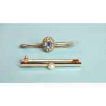 A small bar brooch set a pale blue sapphire within a seed pearl surround, unmarked, 32mm wide and an