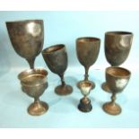 A collection of seven plain engraved trophy cups, various sized, dates and makers, total weight