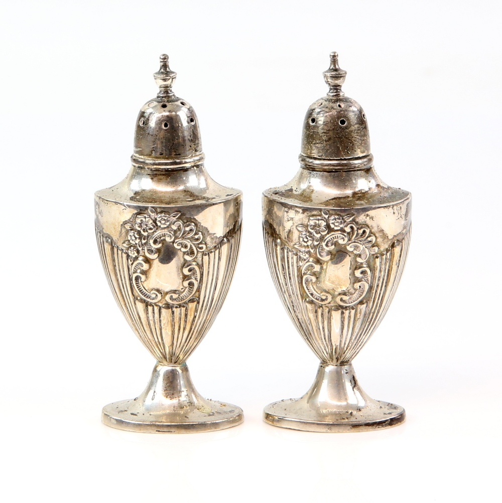 Pair of silver pepperettes with reeded and flower decoration and vacant cartouches by Walker and