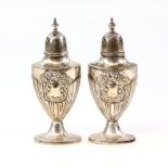 Pair of silver pepperettes with reeded and flower decoration and vacant cartouches by Walker and