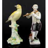 Sitzendorf figurine of a man playing flute and a porcelain figurine of yellow bird on a tree stump