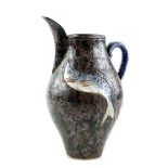 Roger Cockram pottery jug, the handle modelled as a fish and the body of the jug with incised