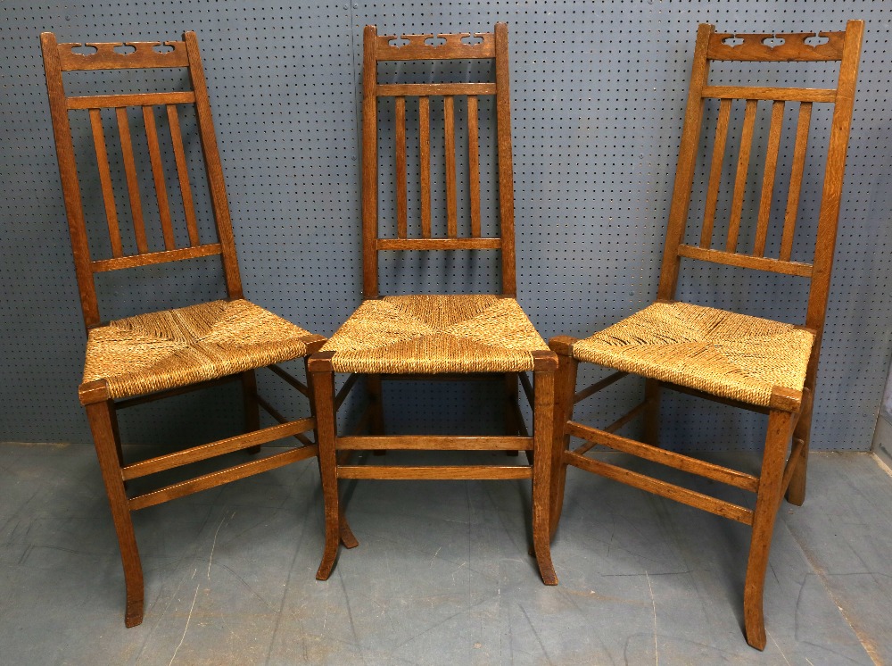 Set of six Arts & Crafts oak chairs with shaped carved splat backs and pierced back rail, sea