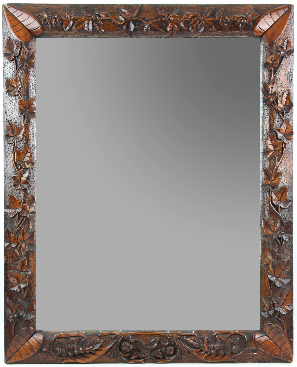 Early 20th C mirror, the wooden frame carved with ivy and laurel leaves, 64 x 80 cm.