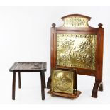 A fire screen in mahogany with Aesthetic Movement brass designed with flowers within a fruit border,