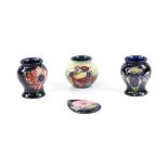 Two small Moorcroft 'Orchid' pattern baluster vases with tube lined decoration on a blue ground,