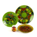 Poole pottery, a Delphis plate in red, yellow and turquoise on a green ground, diameter 35cm,