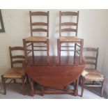 Oak drop leaf table and four matching chairs .