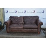 Pair of brown leather sofa and matching footstool,.