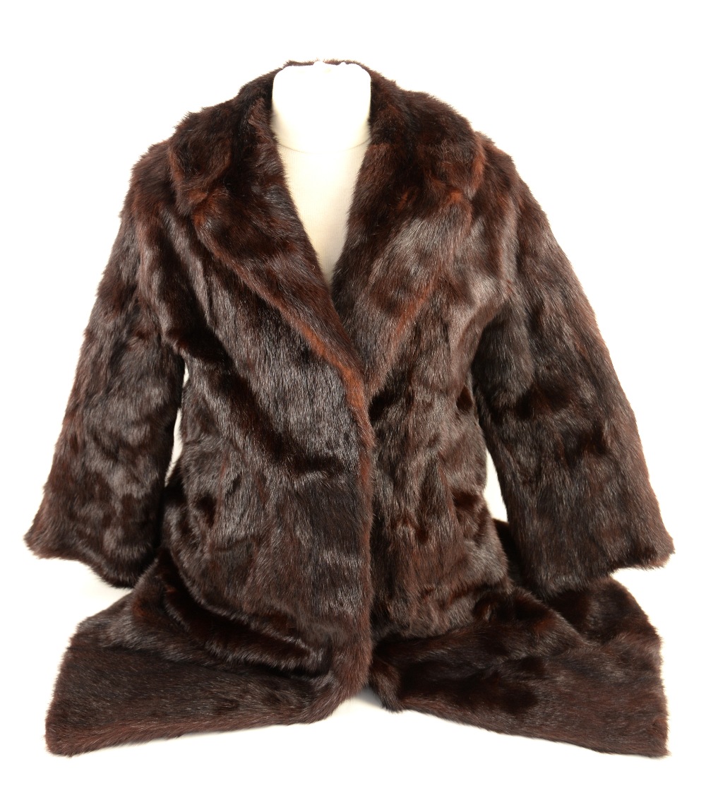 A mink fur coat and a long white coat with black collar, a mink stole, wrap an cape, ermine collar