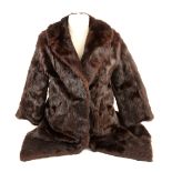 A mink fur coat and a long white coat with black collar, a mink stole, wrap an cape, ermine collar