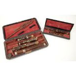 Cased rosewood flute with white metal mounts and a piccolo. .