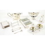 Group of silver items including a large silver sauce boat engraved with a crest, two open salts, a