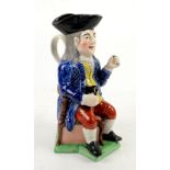 Staffordshire `Squire` Toby jug, the `Squire` seated on a corner chair, 28cm.