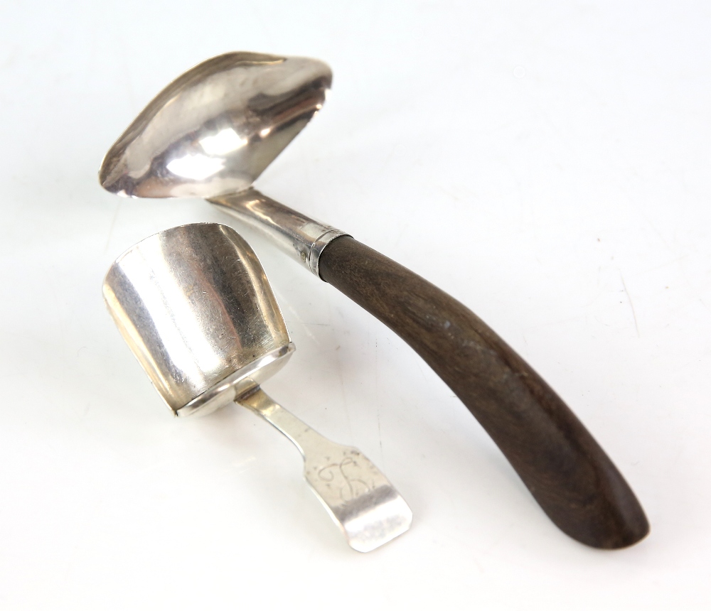 Georgian scoop form silver caddy spoon and a wooden handled silver sauce ladle .