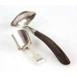 Georgian scoop form silver caddy spoon and a wooden handled silver sauce ladle .