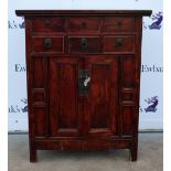 Chinese red lacquered cabinet with six short drawers over panelled doors on square supports, 118cm x