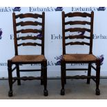 Oak dining table and a set of six oak ladder back dining chairs .