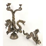 A three branch candelabra in the form of three dragons holding pearls and a similar dragon. Both