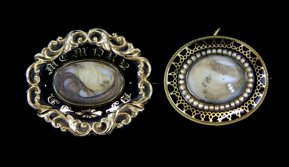 Two Victorian black enamel mourning brooches, one central hair panel surrounded by a fresh water