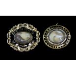 Two Victorian black enamel mourning brooches, one central hair panel surrounded by a fresh water