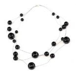 Contemporary floating jet bead necklace with spherical jet with varied size irregularly set on three