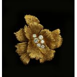 Cartier flower pendant/ brooch set with six brilliant cut diamonds, the petals with textured finish,