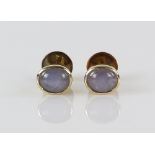 Pair of pale blue star sapphire earrings, in rub over setting, with screw fittings, marked for 14 ct