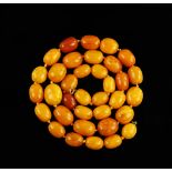Amber necklace, elongated beads strung with knots to a gold bolt ring clasp marked 9 ct, length 72