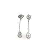 A pair of diamond earrings with pear form drops with a cluster surround, articulated stems,