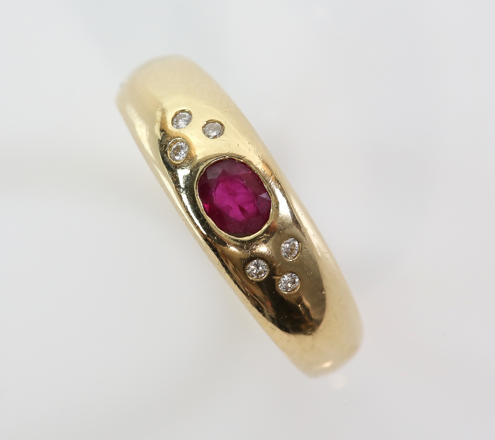 Modern gold band ring inset with a ruby and six small diamonds, marks for 18 ct gold, ring size