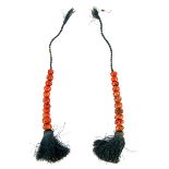 Two Tibetan coral bead sections strung on blue cord, largest coral bead measuring 14mm in