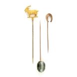 Three stick pins, one in the form of a goat, another set with oval cabochon cut cats eye quartz,