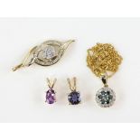 Four gemstone pendants including a blue and white diamond cluster pendant, diamond cluster pendant