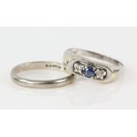 Two rings, one set with a round cut sapphire and two Swiss cut diamonds and a court shaped wedding